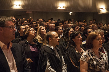 The graduates and assembled friends and family worshipping together in song