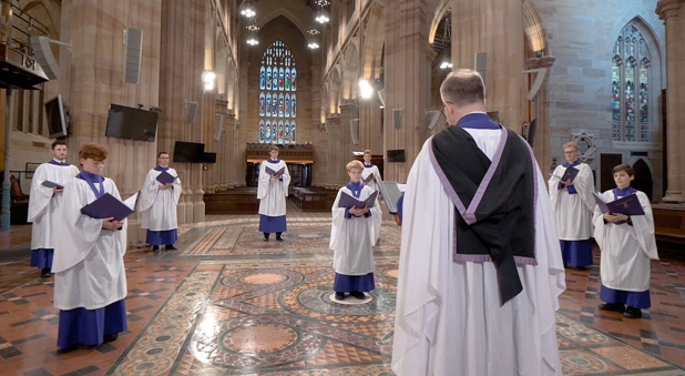 The trimmed down choir, with social distancing, sing a hymn during the TV service